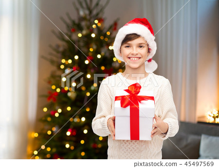 happy boy in santa hat with gift box on christmas happy boy in santa hat with gift box on christmas 45497569