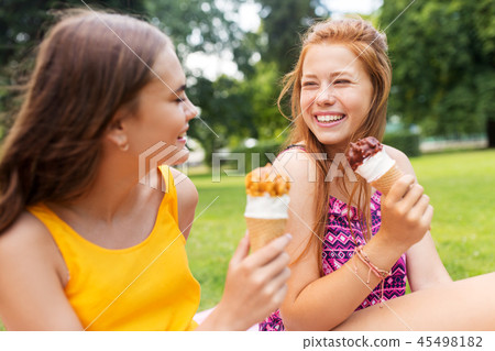 teenage girls eating ice cream at picnic in park teenage girls eating ice cream at picnic in park 45498182