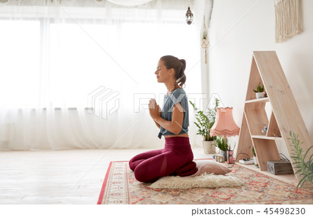 woman meditating in lotus pose at yoga studio 45498230
