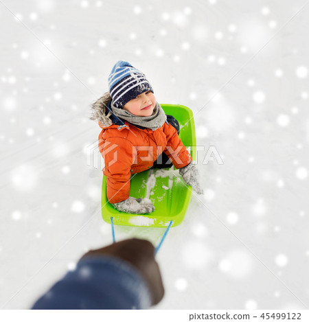 happy boy riding sled on snow in winter 45499122