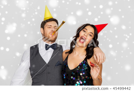 happy couple with party blowers having fun happy couple with party blowers having fun 45499442