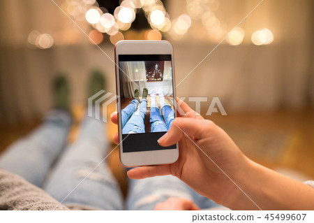 close up of couple taking foot photo by smartphone 45499607