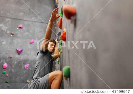 young man exercising at indoor climbing gym 45499647