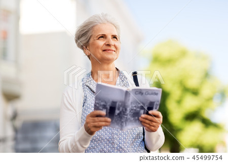 senior woman or tourist with city guide outdoors 45499754