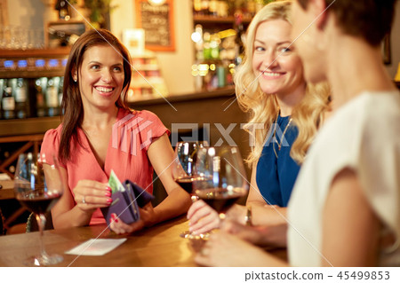 women paying bill at wine bar or restaurant 45499853