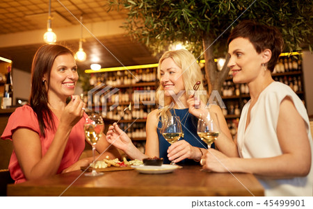 women eating snacks at wine bar or restaurant 45499901