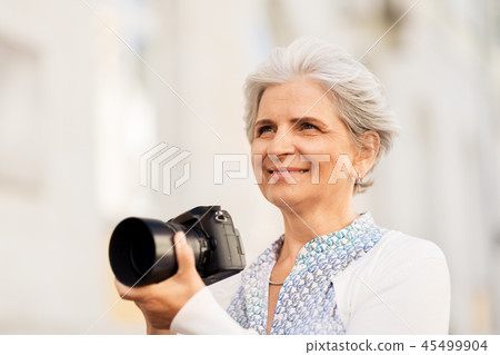 senior woman photographing by digital camera 45499904
