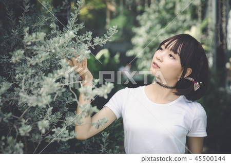portrait of asian girl with white shirt and skirt looking in outdoor nature vintage film style 45500144