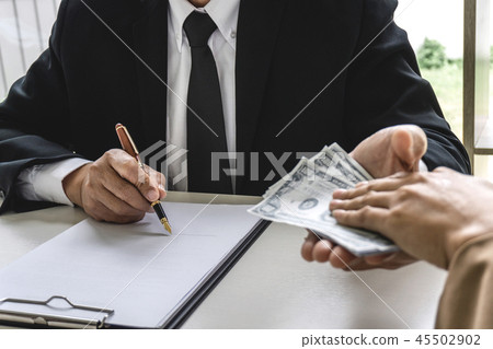 Business woman giving bribe money the form of dollar bills to ma 45502902