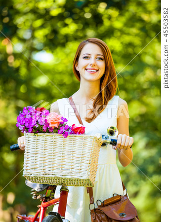 Style redhead girl in white dress with red bike Style redhead girl in white dress with red bike 45503582