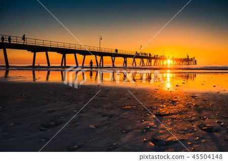 Silhouettes walking along jetty 45504148