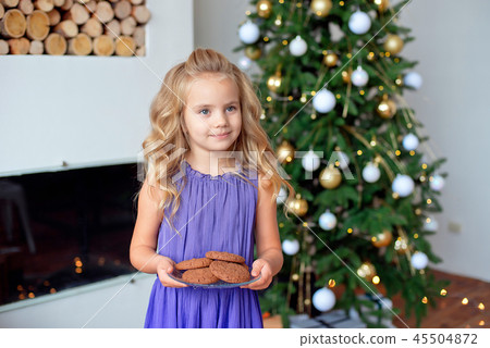 A little girl with blond hair prepared treats for Sanda. Christmas background, new year concept A little girl with blond hair prepared treats for Sanda. Christmas background, new year concept 45504872