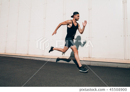 Runner man running fast in industrial city background Runner man running fast in industrial city background 45508900