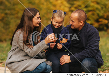 Father and two daughters in the forest. Autumn weather and colorful background. Happy family. Two Father and two daughters in the forest. Autumn weather and colorful background. Happy family. Two 45509531
