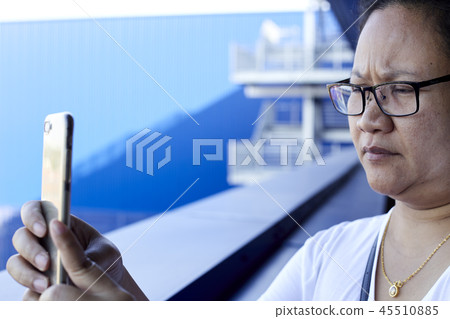 Woman using mobile phone to take photo 45510885