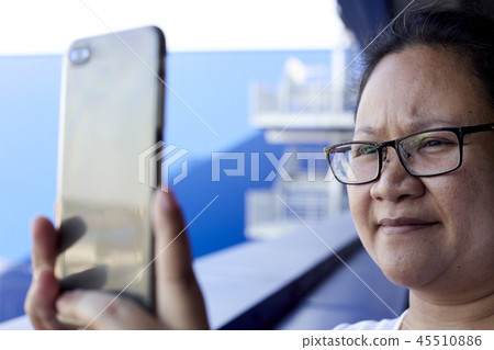 Woman using mobile phone to take photo 45510886
