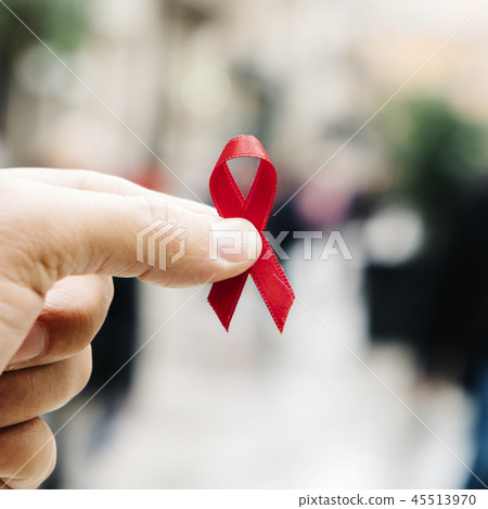 man with a red ribbon for the fight against AIDS 45513970