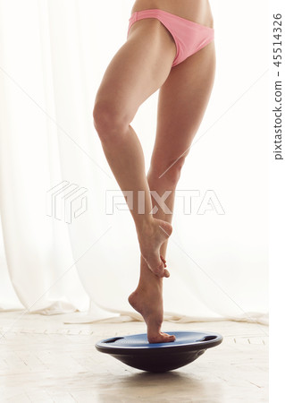 Ballet dancer balances bosu hemisphere 45514326