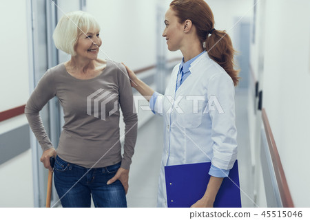 Smiling doctor is talking with female patient with stick 45515046