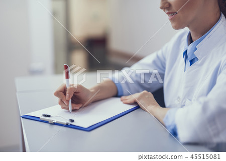 Medical worker is jotting down in clipboard Medical worker is jotting down in clipboard 45515081