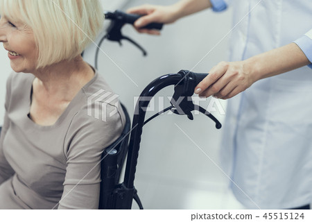 Happy aged woman is moving on wheelchair with medic help Happy aged woman is moving on wheelchair with medic help 45515124