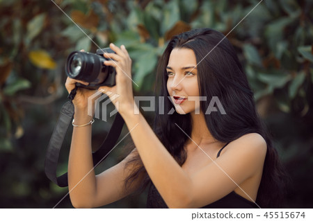 Beautiful Brunette Woman Taking a Picture Outdoor by Digital Camera 45515674