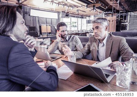 Serious bearded young man concentrating on useful talk 45516953