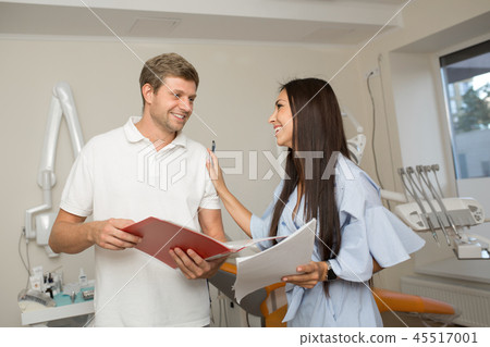 doctor and his assistant looking folder with paper doctor and his assistant looking folder with paper 45517001