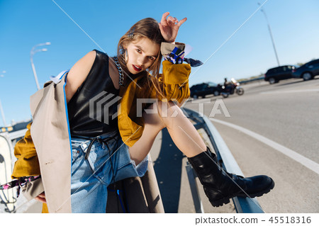 Famous model wearing black leather boots posing outside 45518316