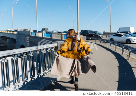 Fashionable dark-haired woman feeling free crossing the bridge Fashionable dark-haired woman feeling free crossing the bridge 45518411