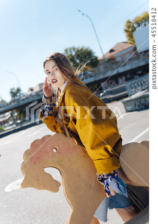 Fashionable model with bright red lips working the street while posing Fashionable model with bright red lips working the street while posing 45518412