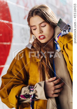 Young dark-haired model with red lips wearing yellow jacket 45518433