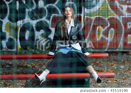 Fashionable young photo model wearing denim and black skirt posing 45519196