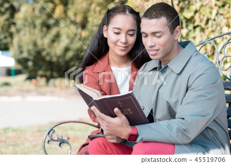Cheerful loving couple reading religious literature together 45519706