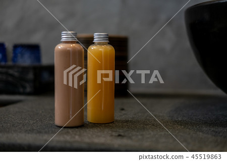 Spa cosmetics in bottles on dark gray table Spa cosmetics in bottles on dark gray table 45519863