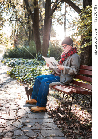 Smart aged man reading a newspaper in the park Smart aged man reading a newspaper in the park 45520785