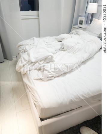 Close up white bedding sheets and pillow on wall room background, Messy bed concept at evening Close up white bedding sheets and pillow on wall room background, Messy bed concept at evening 45520851