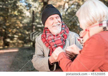 Delighted cheerful loving couple holding hands together Delighted cheerful loving couple holding hands together 45520895