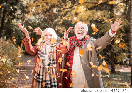 Happy joyful couple looking at the autumn leaves Happy joyful couple looking at the autumn leaves 45521224