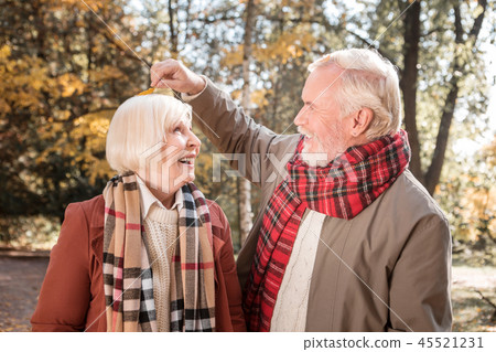 Positive nice man taking a leaf from his wifes head 45521231