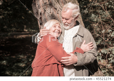 Joyful elderly woman standing with her husband Joyful elderly woman standing with her husband 45521274