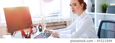 Young girl in the office working with documents at the computer. 45521894