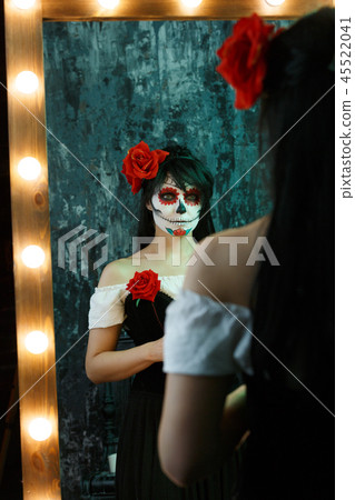 Picture of zombie woman with white face , red flower on her head 45522041