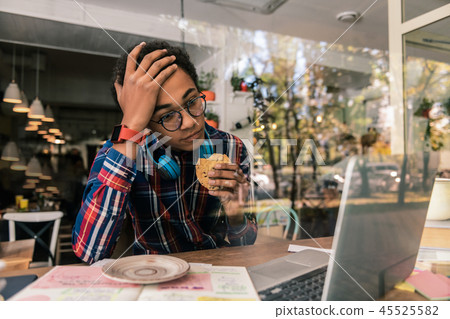Pleasant nice student holding a delicious cookie 45525582