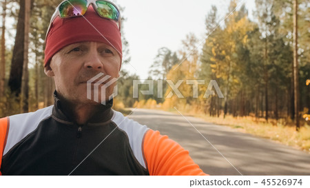 Training an athlete on the roller skaters. Biathlon ride on the roller skis with ski poles, in the Training an athlete on the roller skaters. Biathlon ride on the roller skis with ski poles, in the 45526974
