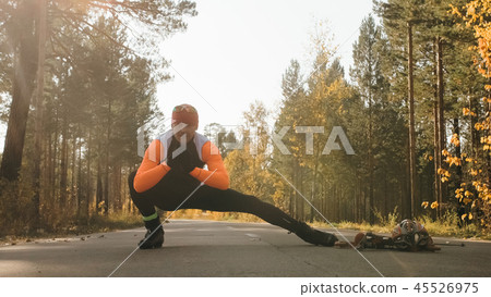 Training an athlete on the roller skaters. Biathlon ride on the roller skis with ski poles, in the Training an athlete on the roller skaters. Biathlon ride on the roller skis with ski poles, in the 45526975