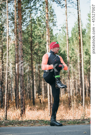 Training an athlete on the roller skaters. Biathlon ride on the roller skis with ski poles, in the Training an athlete on the roller skaters. Biathlon ride on the roller skis with ski poles, in the 45527007