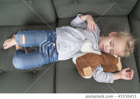child sleeping on the couch in clothes 45530451