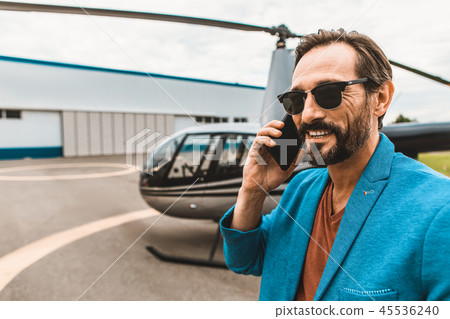 Happy bearded man talking on the phone and smiling 45536240
