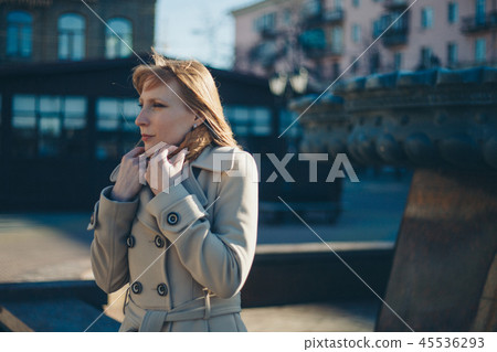 beautiful girl walking down the street in a coat 45536293